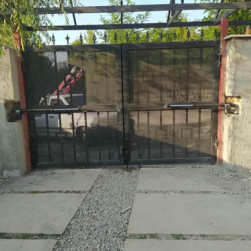 جک بازویی مشکی روی درب فلزی پارکینگ