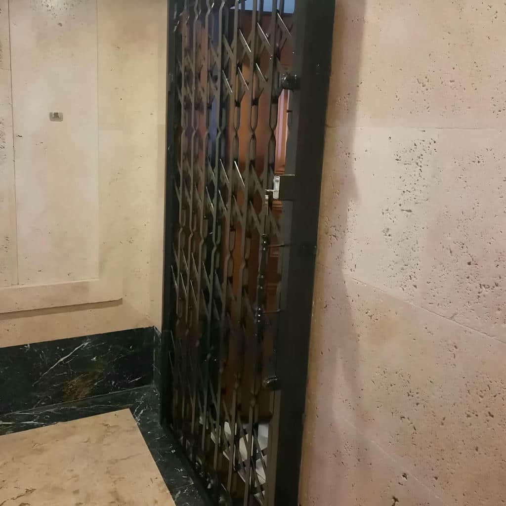 گارد فلزی جمع شده کنار دیوار راهروی مسکونی
